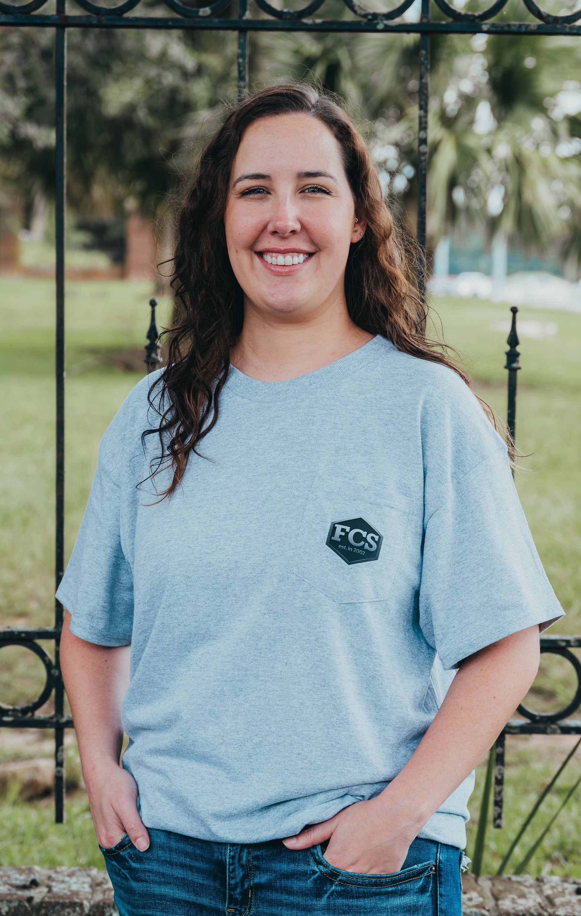 A woman wearing a blue shirt and a black jacket smiles for the camera