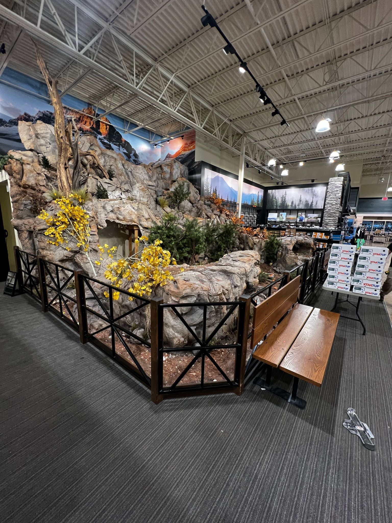 A large room with a fence and a bench in it