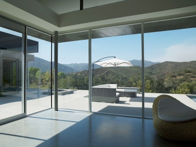 A room with a lot of windows and a chair