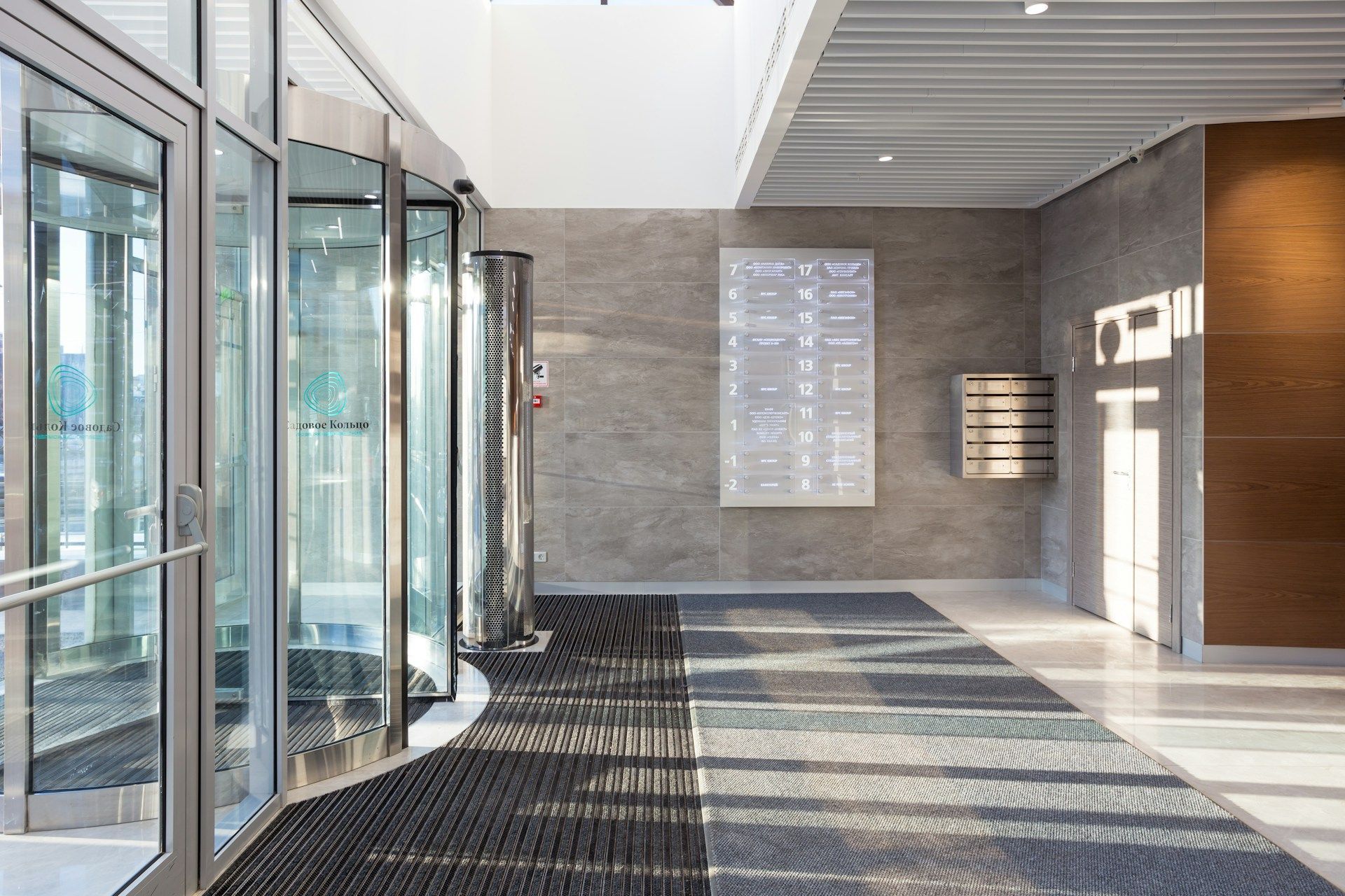 A long hallway in a building with a black mat on the floor.