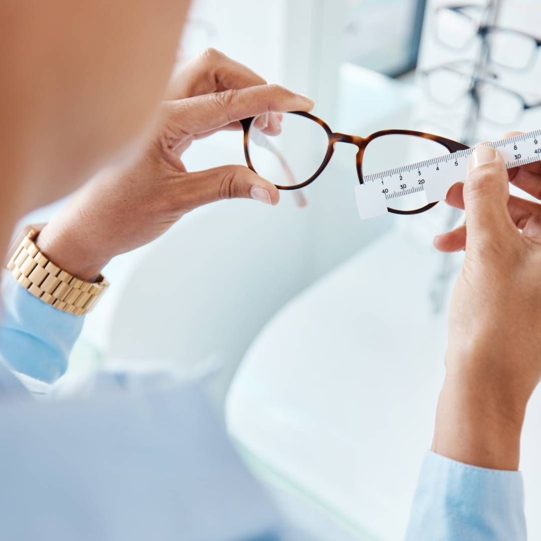 A woman is holding a pair of glasses in her hands.