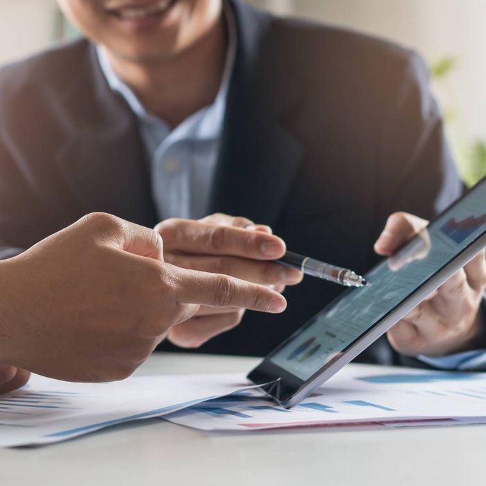 A man and a woman are looking at a tablet together.