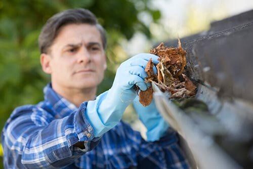 Man Clearing Leaves From Guttering - Gutter cleaning in Englewood, NJ