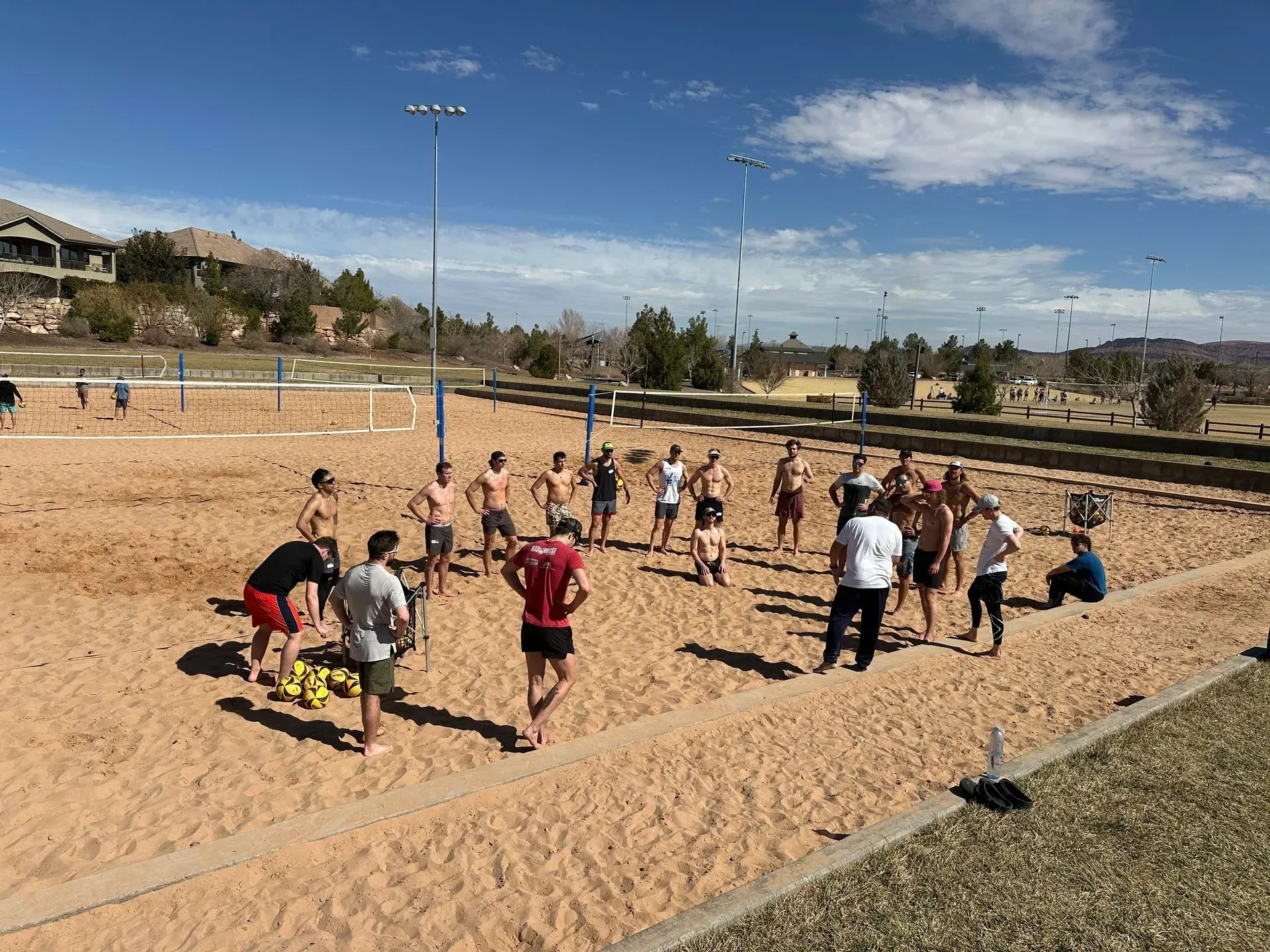 People playing volleyball on a sand court. 