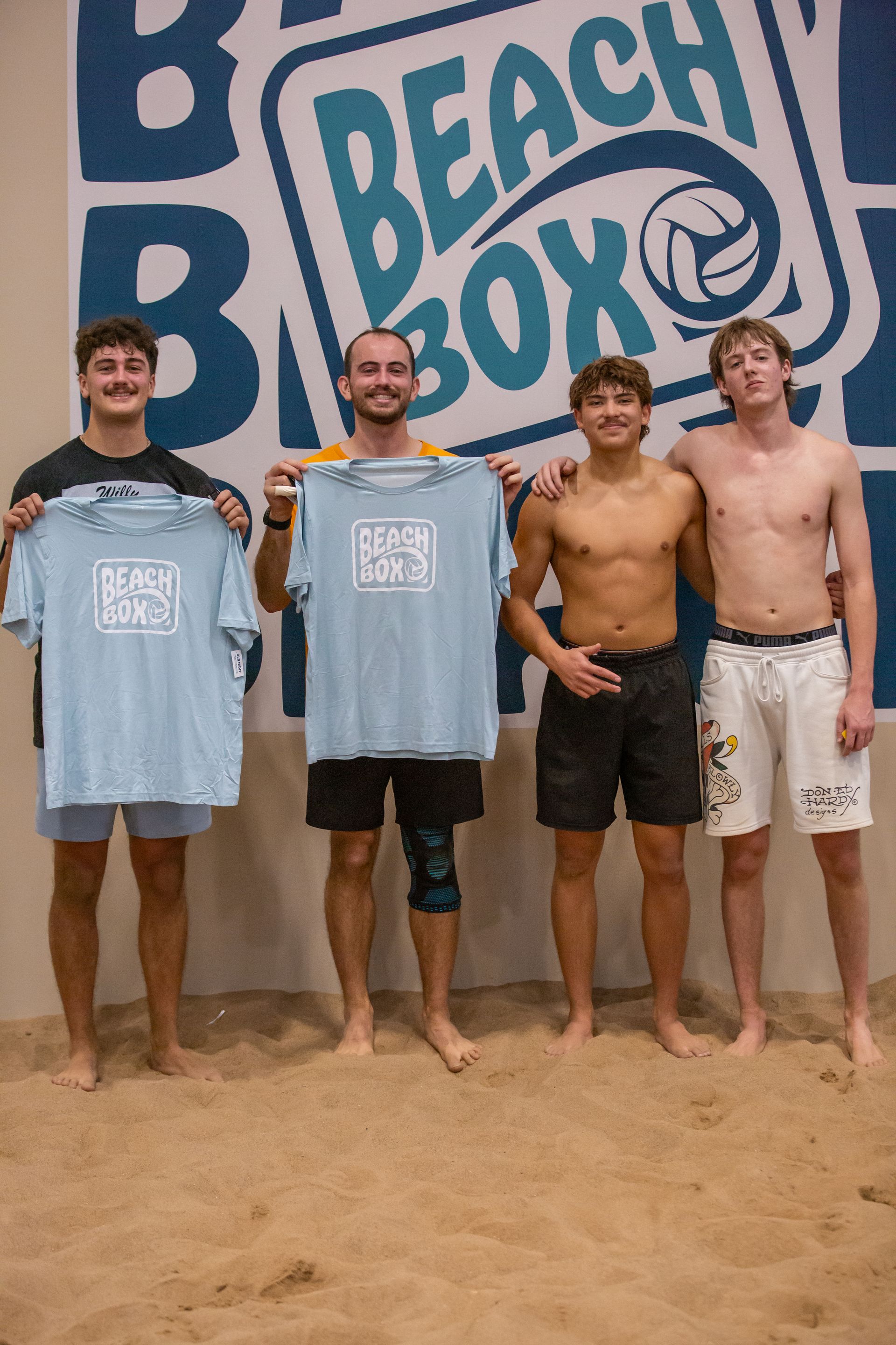 People playing volleyball on a sand court. 