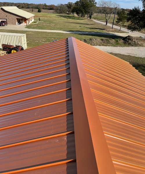 A close up of a brown metal roof with a ridge.