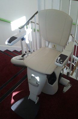 Reconditioned Curved Stairlift at the top of the stairs