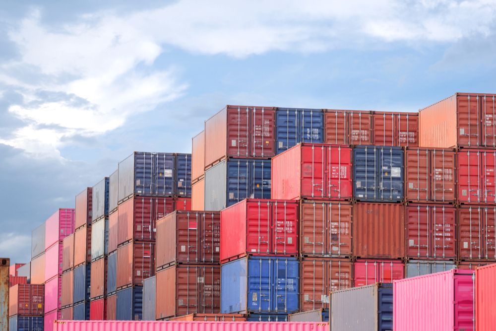 Stacks of Colourful Shipping Containers Against a Cloudy Sky — Johnny Farming Company In Ooralea, QLD