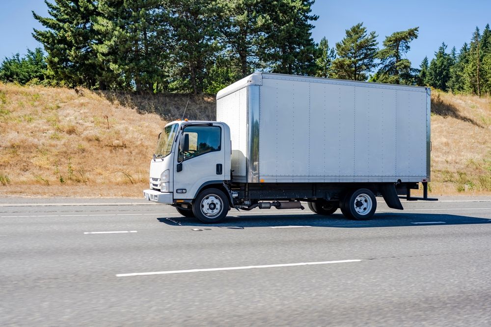 White Box Truck Driving on a Highway, Trees in the Background, Sunny Day — Johnny Farming Company In Ooralea, QLD