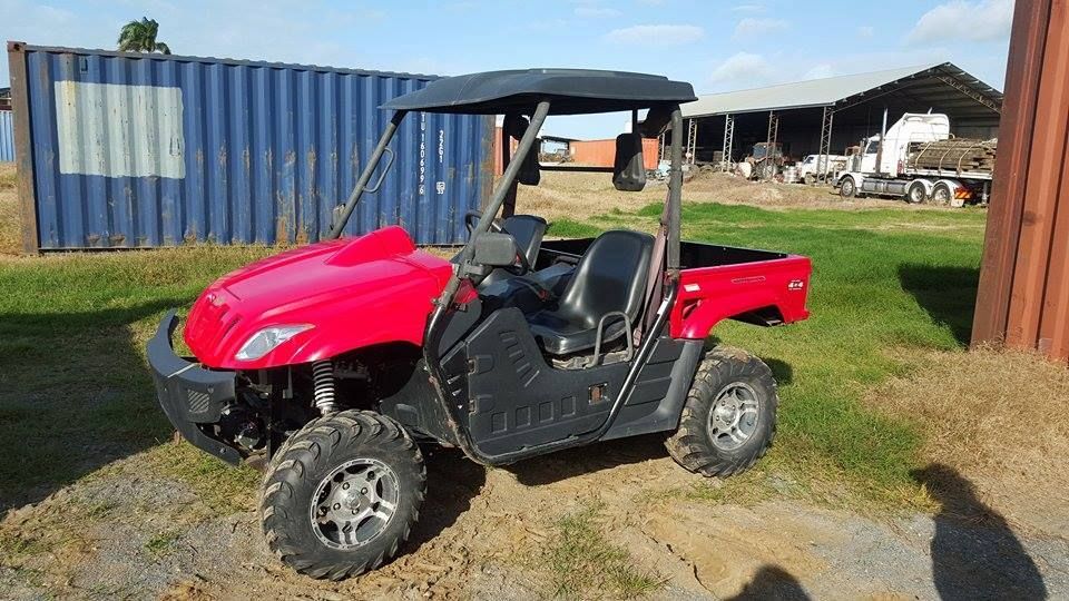 Red and Black Side-by-side Utility Vehicle With a Black Roof, Parked on Grass — Johnny Farming Company In Ooralea, QLD