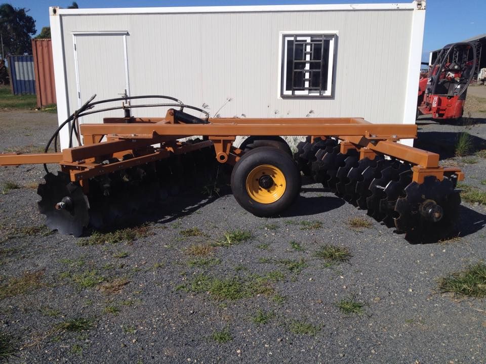 A Tractor Is Parked In Front Of A Small White Building — Johnny Farming Company In Ooralea, QLD