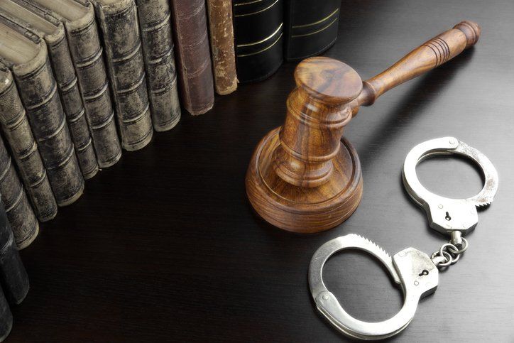 Judges gavel, handcuffs and old book on the black table — San Antonio, TX — A-Action Bail Bonds