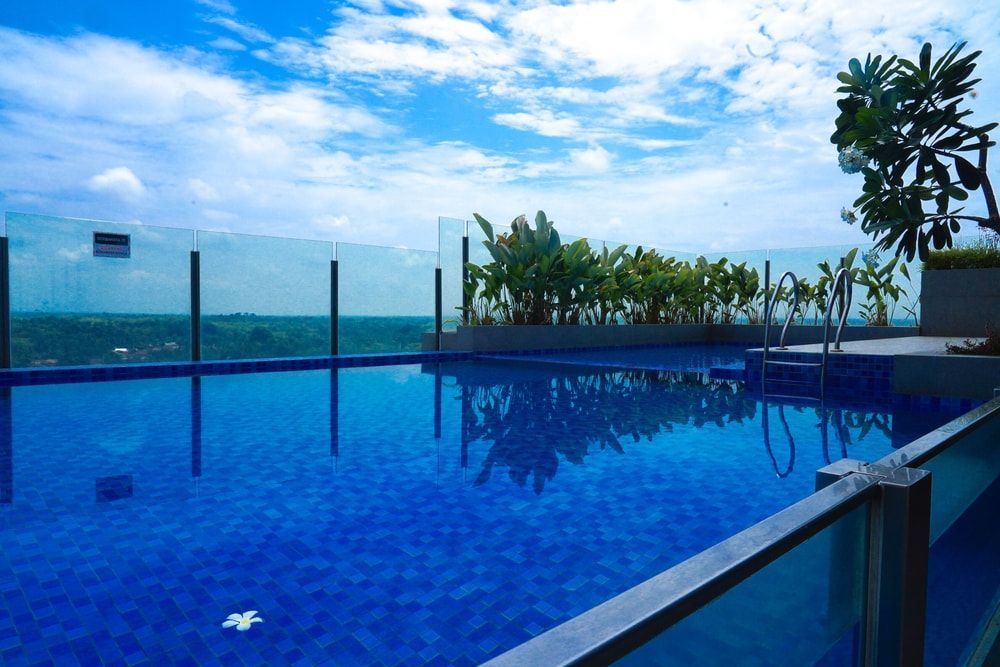 Rooftop pool with clear blue water, glass barriers, and a bright blue sky. — Gympie Fence Inspections in Curra, QLD