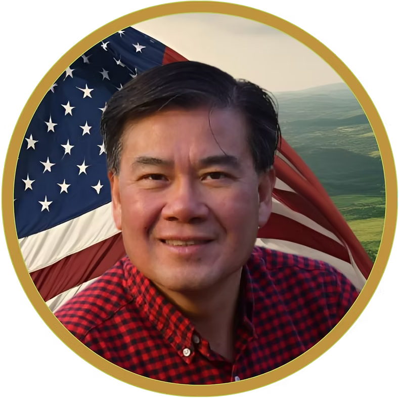 Smiling man in a red plaid shirt before a U.S. flag and coastal background in a gold-rimmed portrait