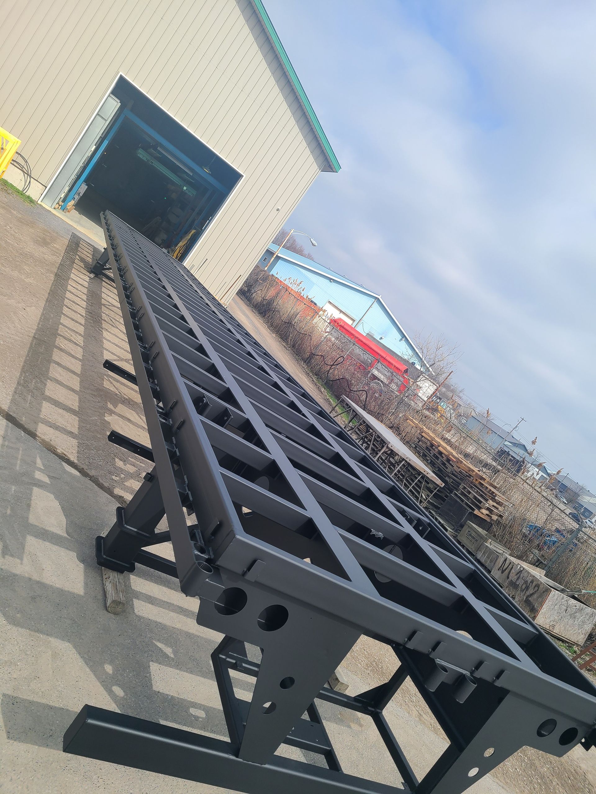 Une grande structure métallique est assise devant un bâtiment