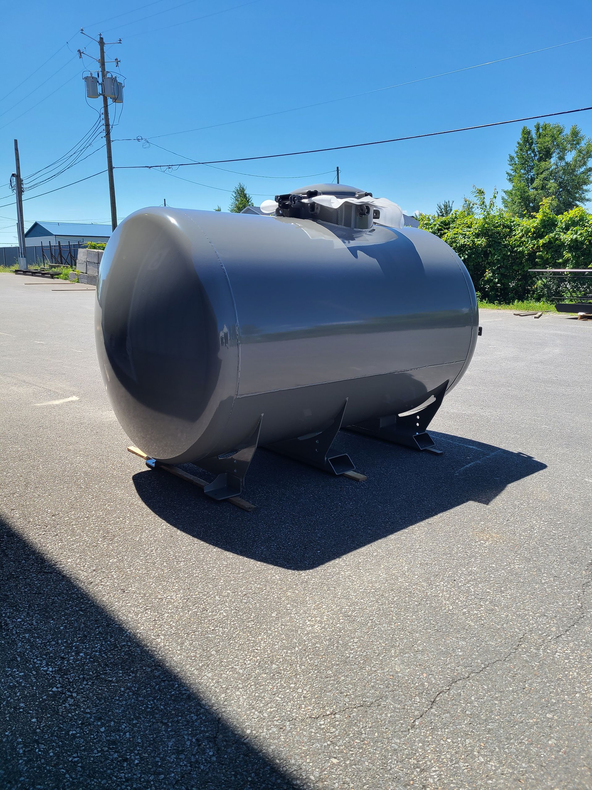 Un grand cylindre gris est assis sur le bord d'une route.