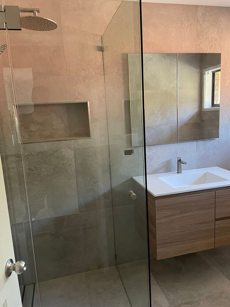 A Bathroom with A Walk in Shower, Sink and Mirror — Tradewind Building Maintenance in Balgownie,NSW