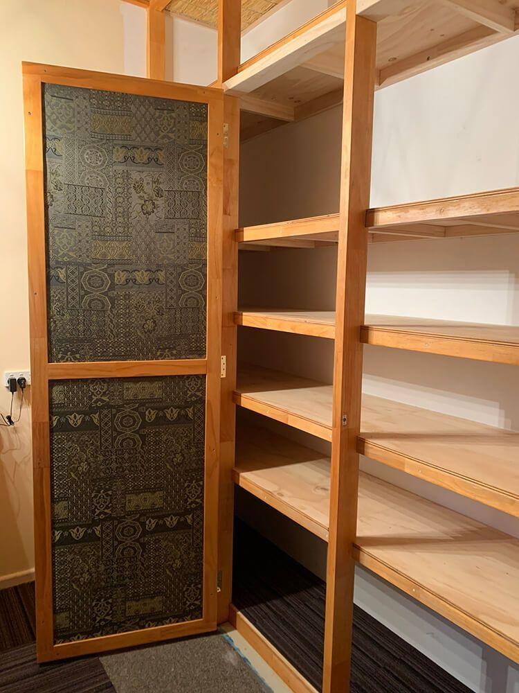 A Closet with Shelves and A Door with A Pattern on It — Tradewind Building Maintenance in Wollongong,NSW
