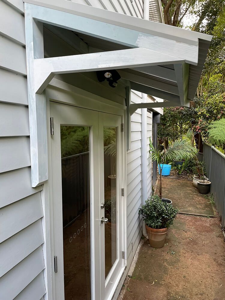 A White House with A Canopy Over the Door — Tradewind Building Maintenance in Balgownie,NSW
