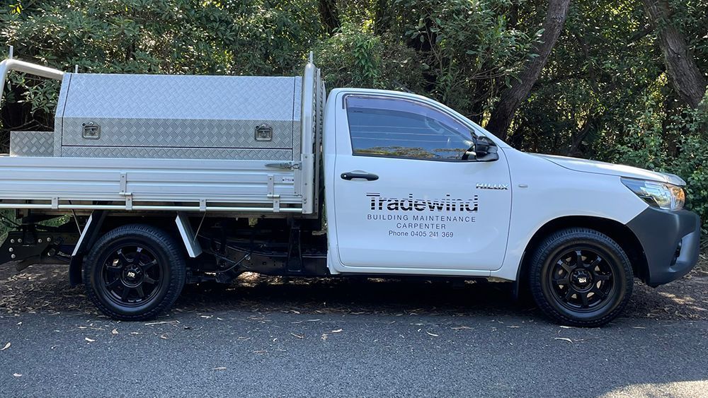 A White Truck Is Parked on The Side of The Road — Tradewind Building Maintenance in Woonona,NSW