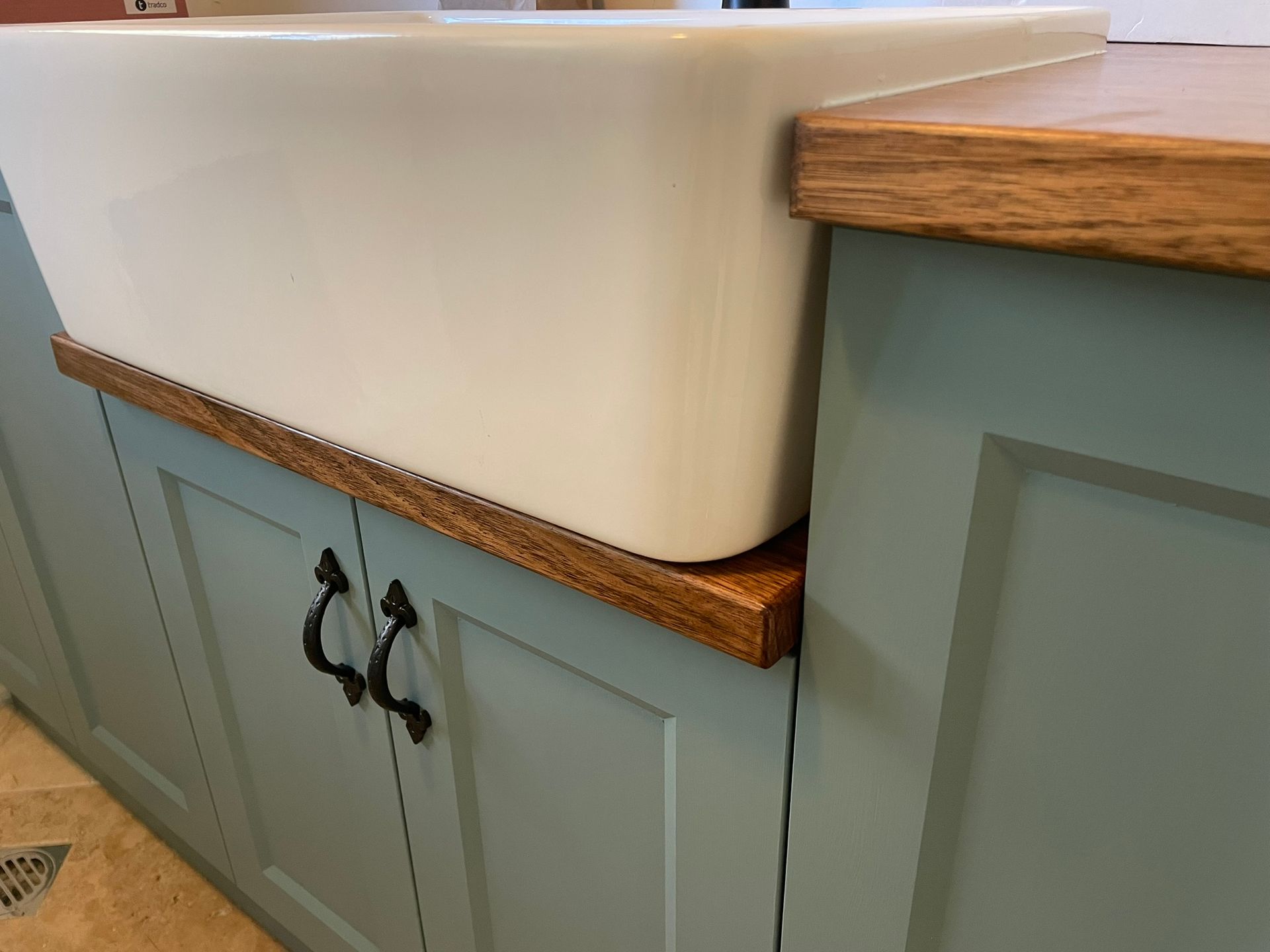 A Kitchen with Wooden Cabinets and A Striped Rug on The Floor — Tradewind Building Maintenance in Woonona,NSW