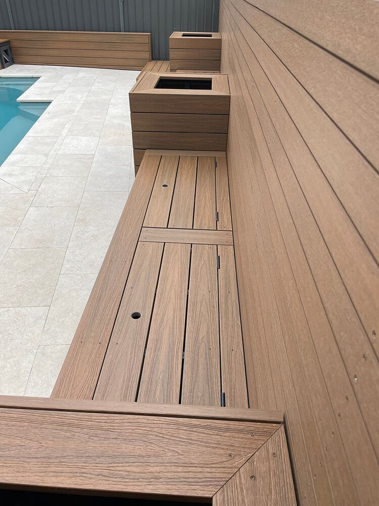 A Wooden Bench Is Mounted Next to A Swimming Pool — Tradewind Building Maintenance in Balgownie,NSW