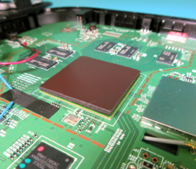 A close up of a green motherboard with a brown square on top