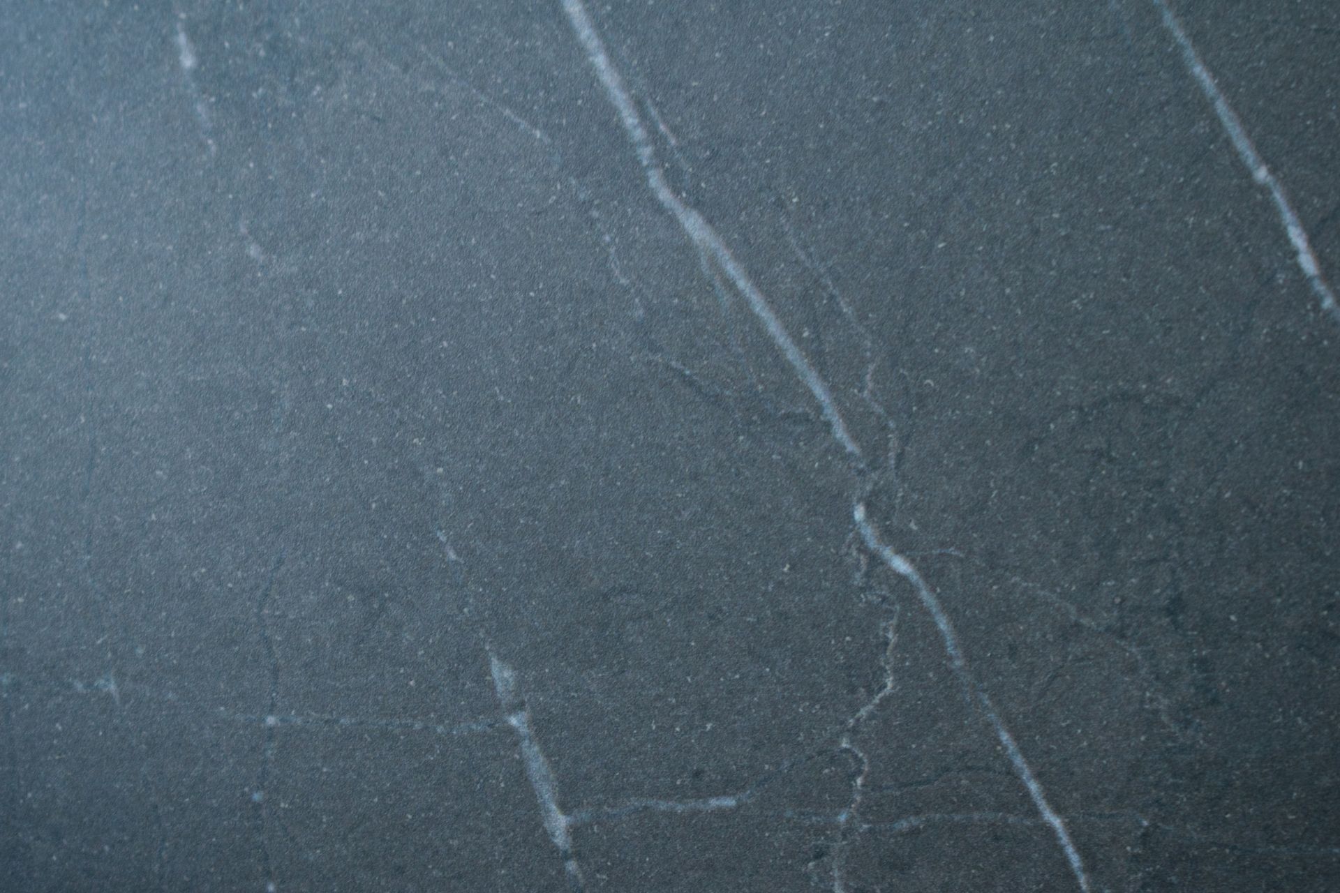 Dark gray stone surface with white veins.
