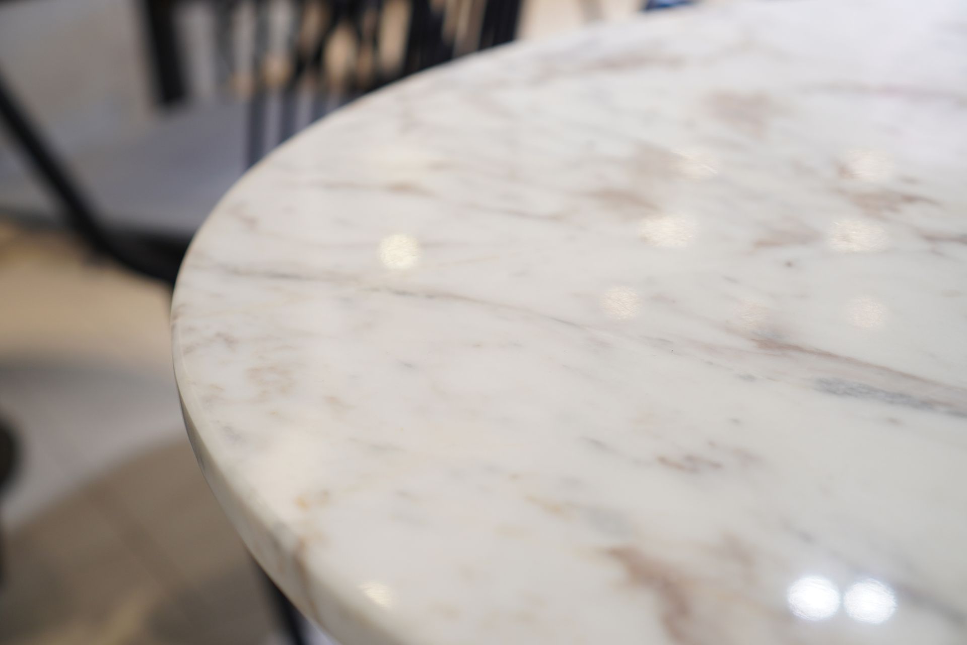 Close-up of a white marble table with brown veining and a shiny surface.