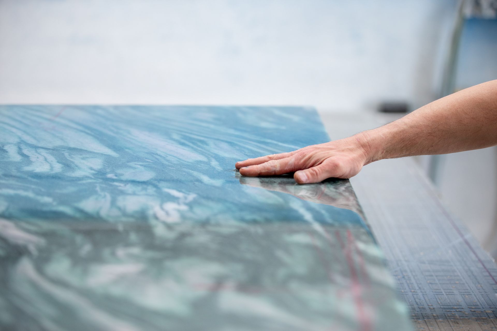 Hand smoothing blue marbled surface.