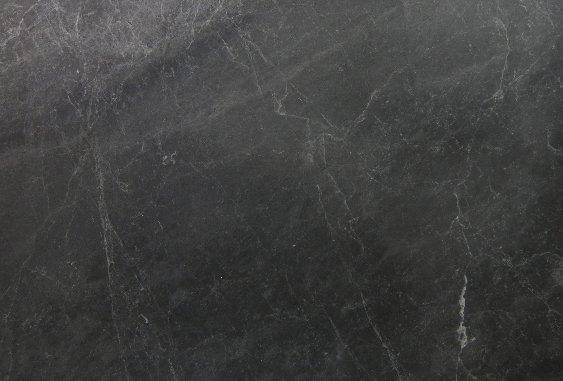 Dark gray leather surface with light-colored creases and markings.