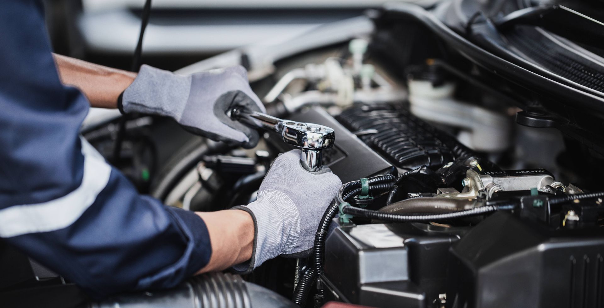 Mechanic using a socket wrench on a car's transmission at Mr. Transmission near Sharonville, OH