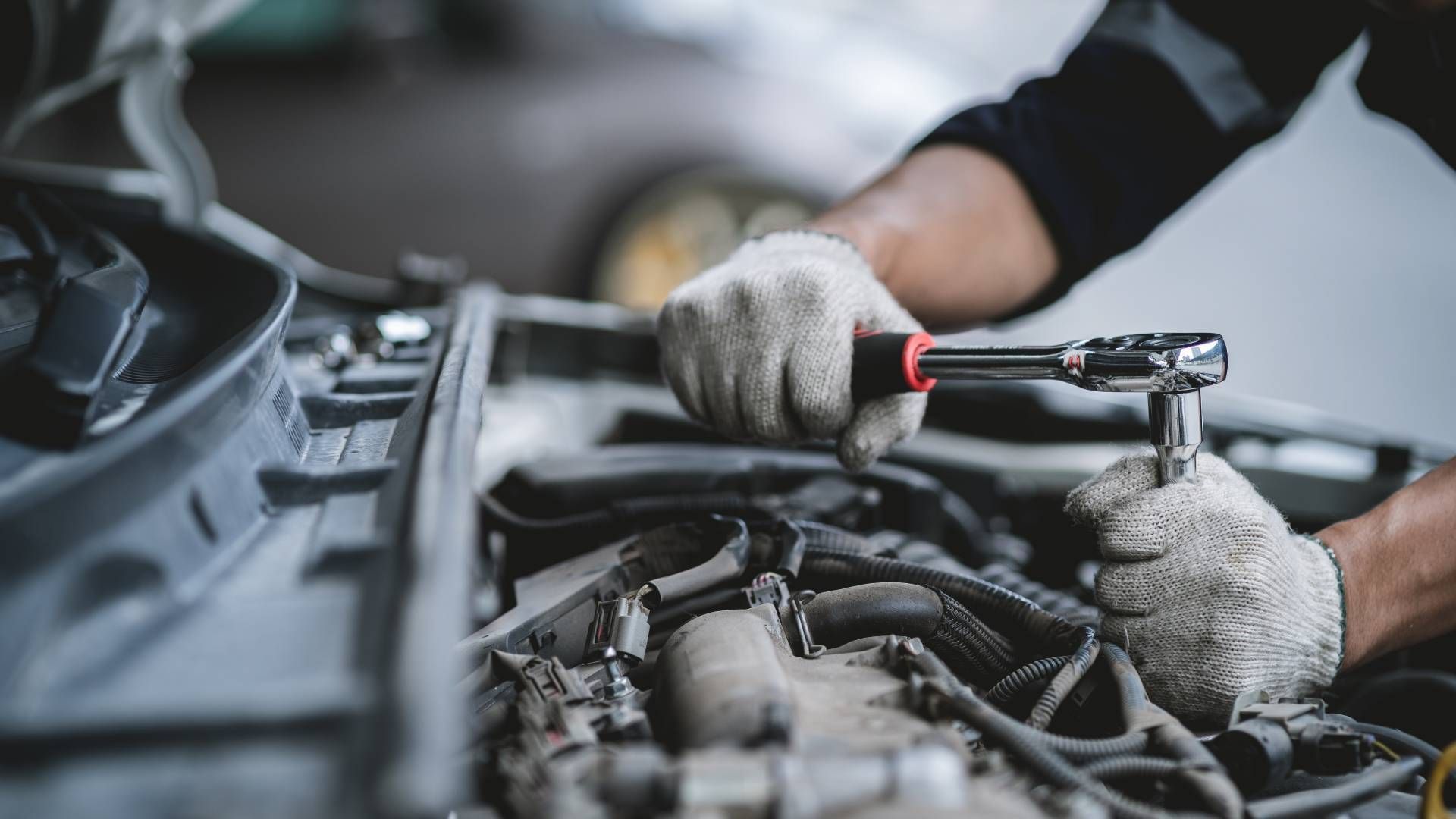 Car mechanic working on a transmission in a garage near Cincinnati, OH