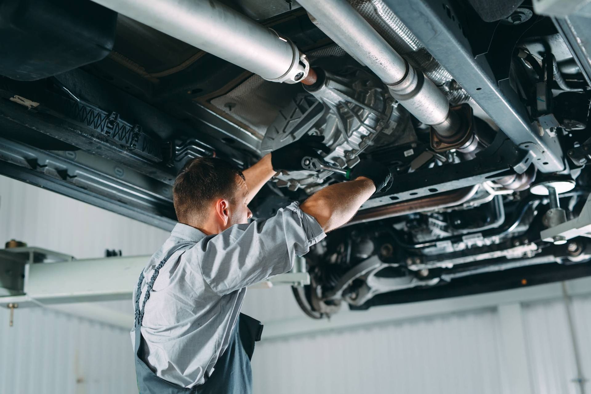 Mechanic working on a lifted car in a transmission mechanic shop near Cincinnati, OH