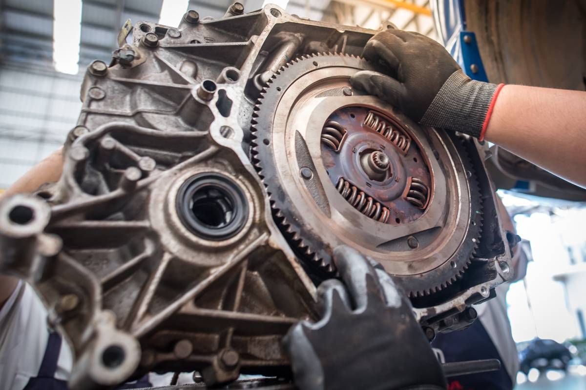 Two auto mechanics working on part of an engine at Mr. Transmission near Cincinnati, OH