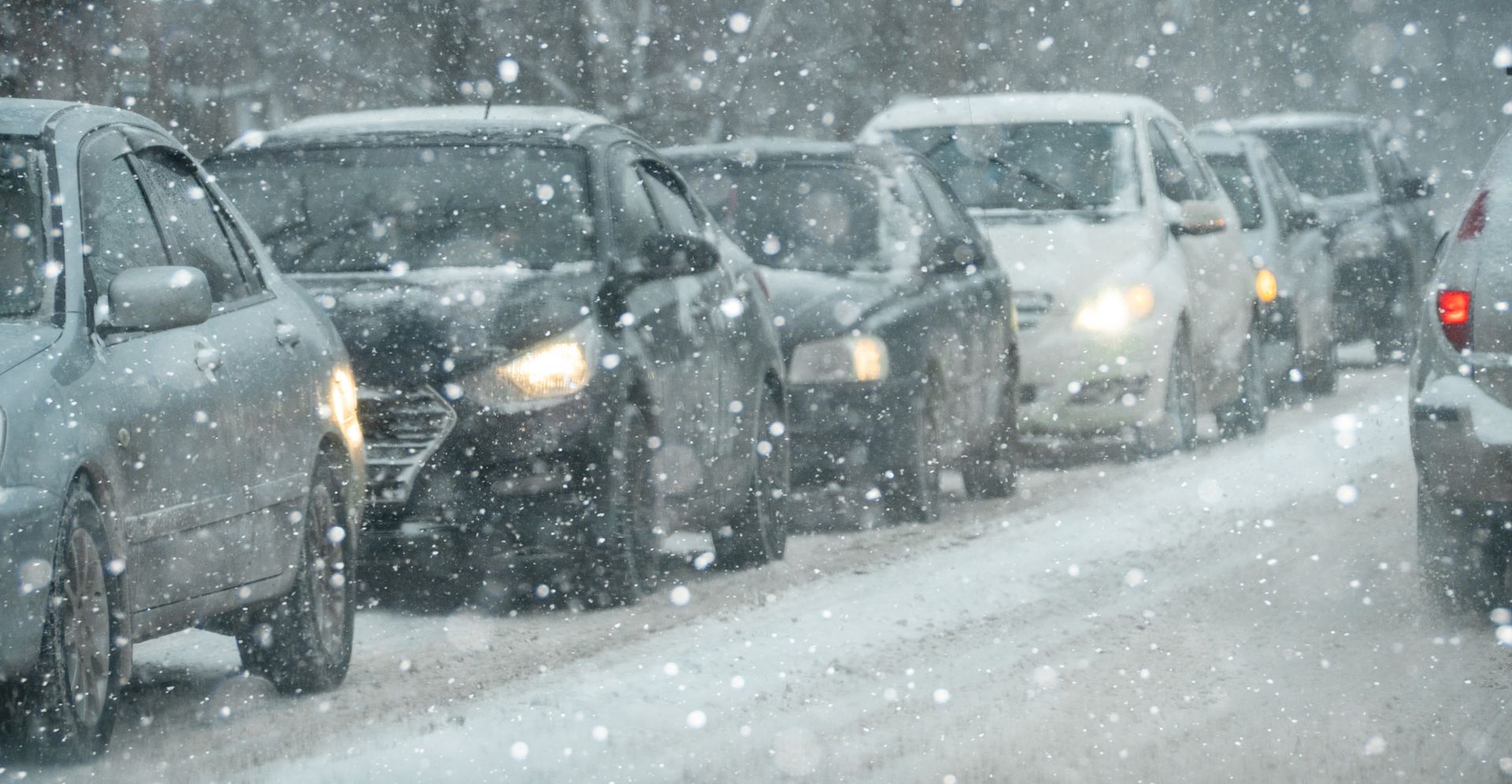 Row of cars in gridlock traffic during a snowy day.
