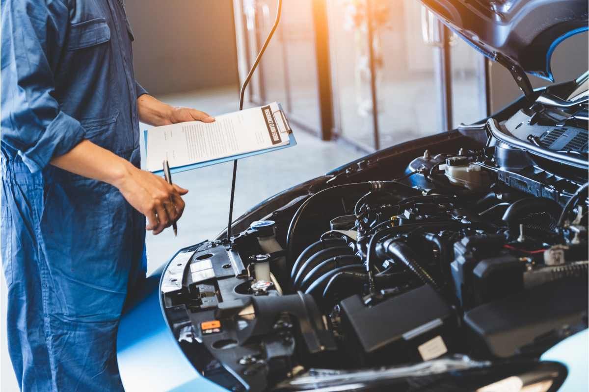 mechanic standing in front of a car in a transmission repair shop near Sharonville, Ohio (OH)