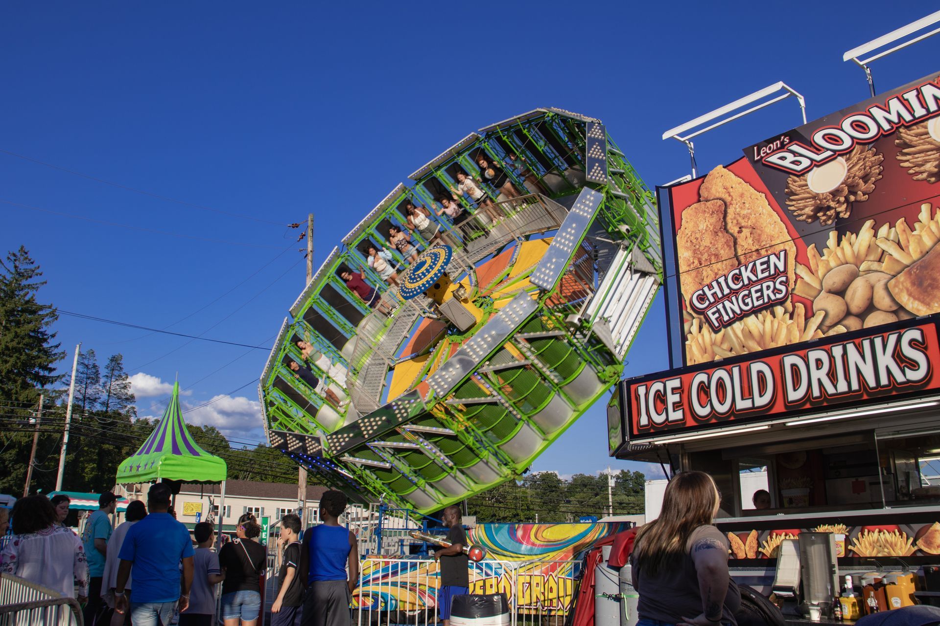 A group of people are standing in front of a carnival ride.