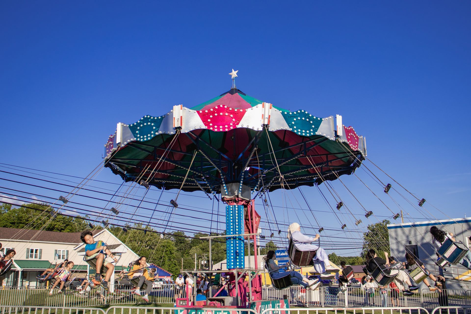 A group of people are riding a merry go round at a carnival.
