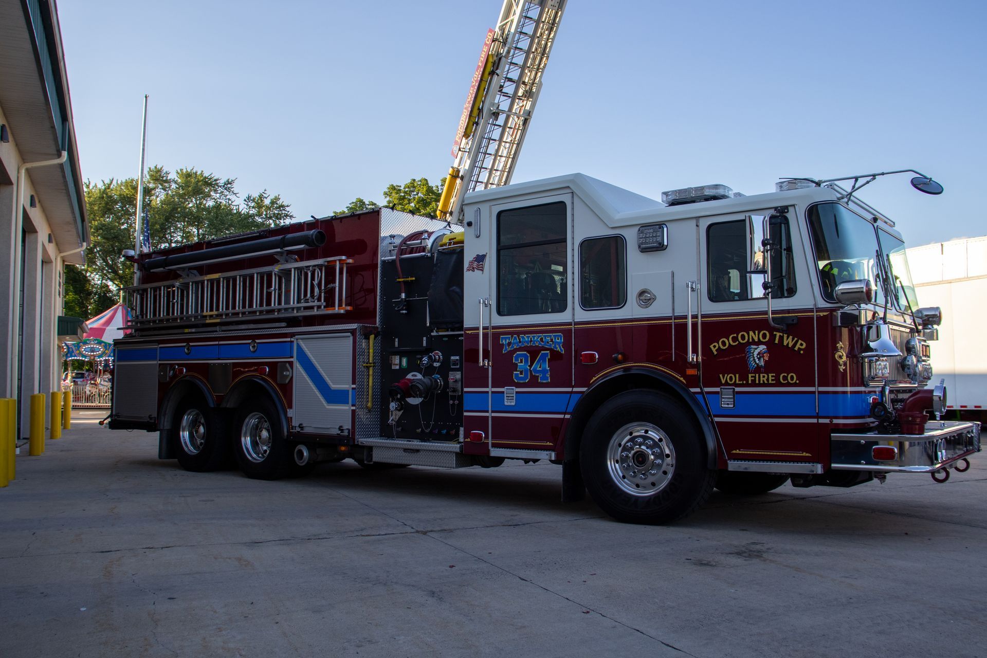 A red , white and blue fire truck is parked in front of a building.