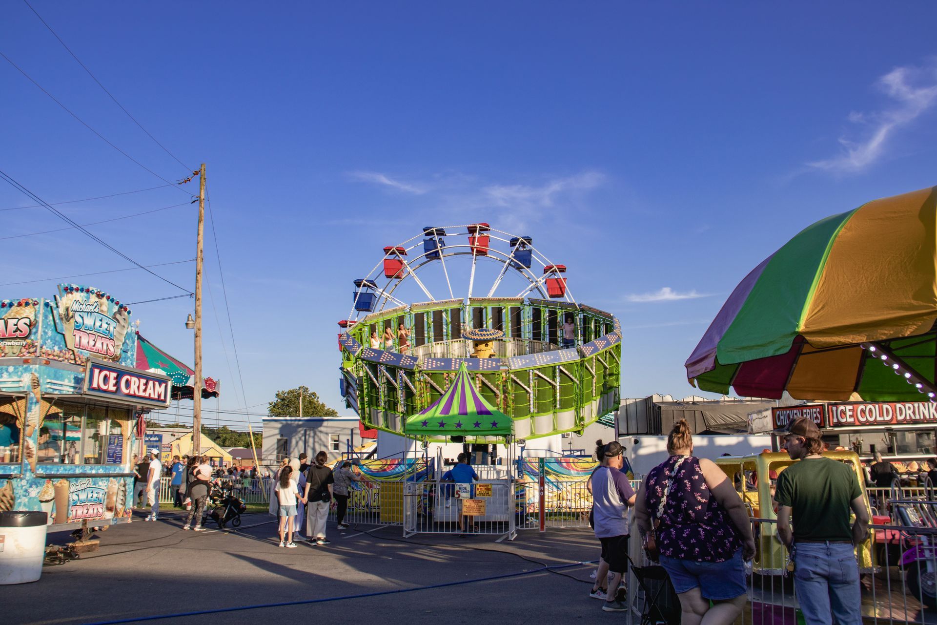 A group of people are standing in front of a ride at a carnival.