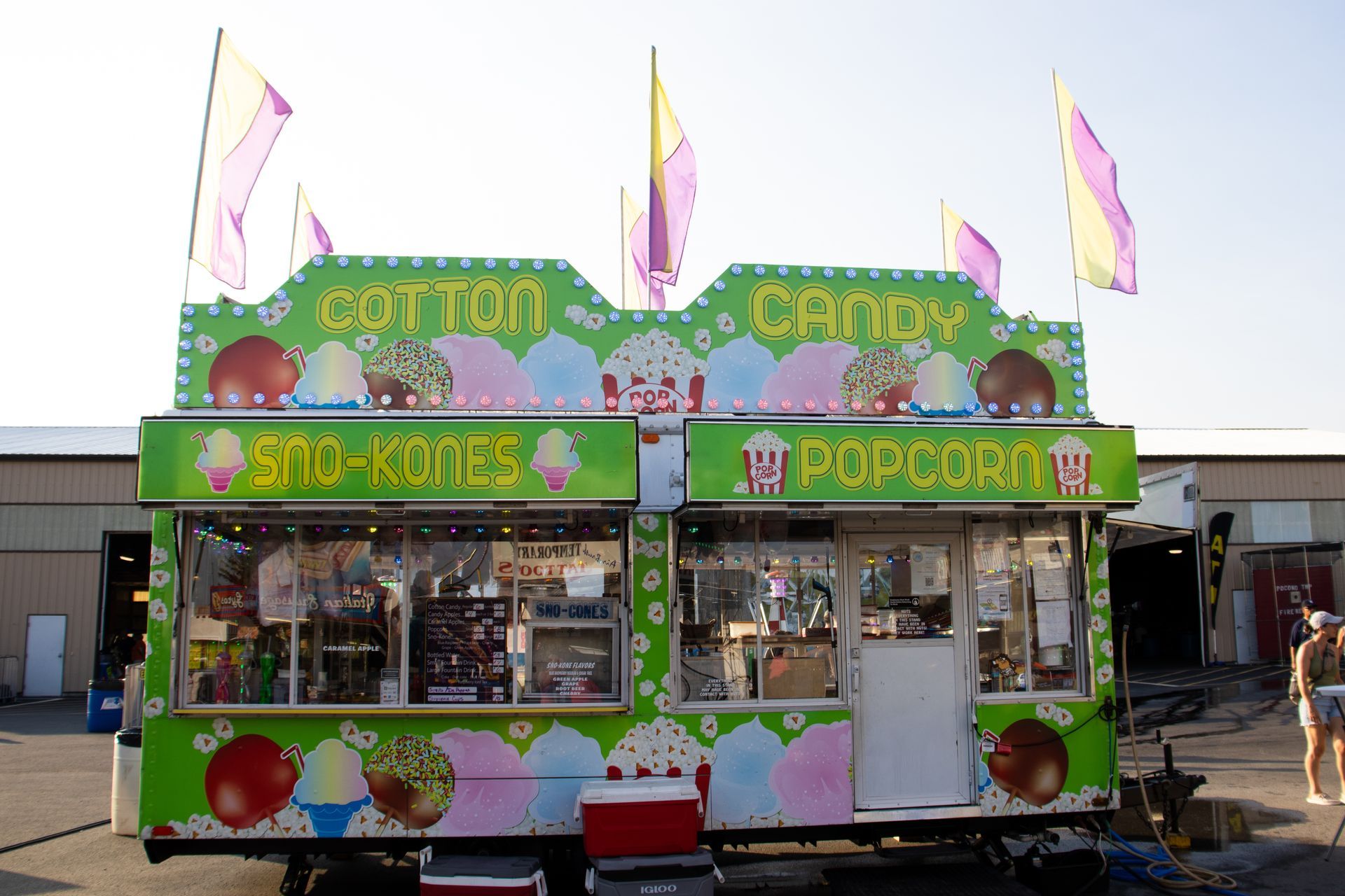 A cotton candy and popcorn stand with flags on top