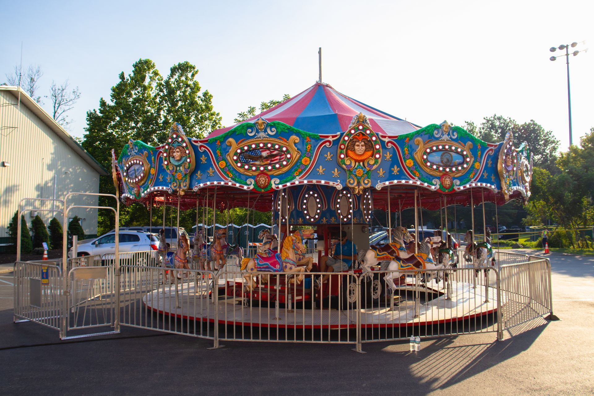 A merry go round with people riding it in a parking lot