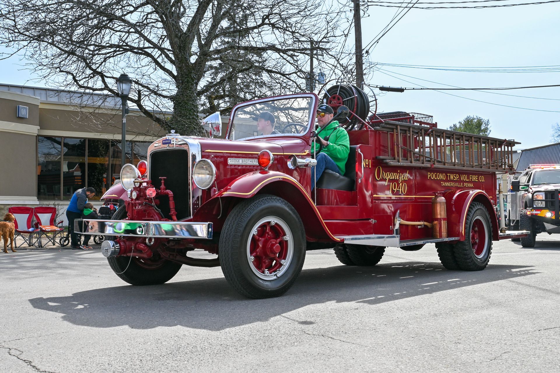 An old red fire truck is driving in the St. Patrick's Day parade