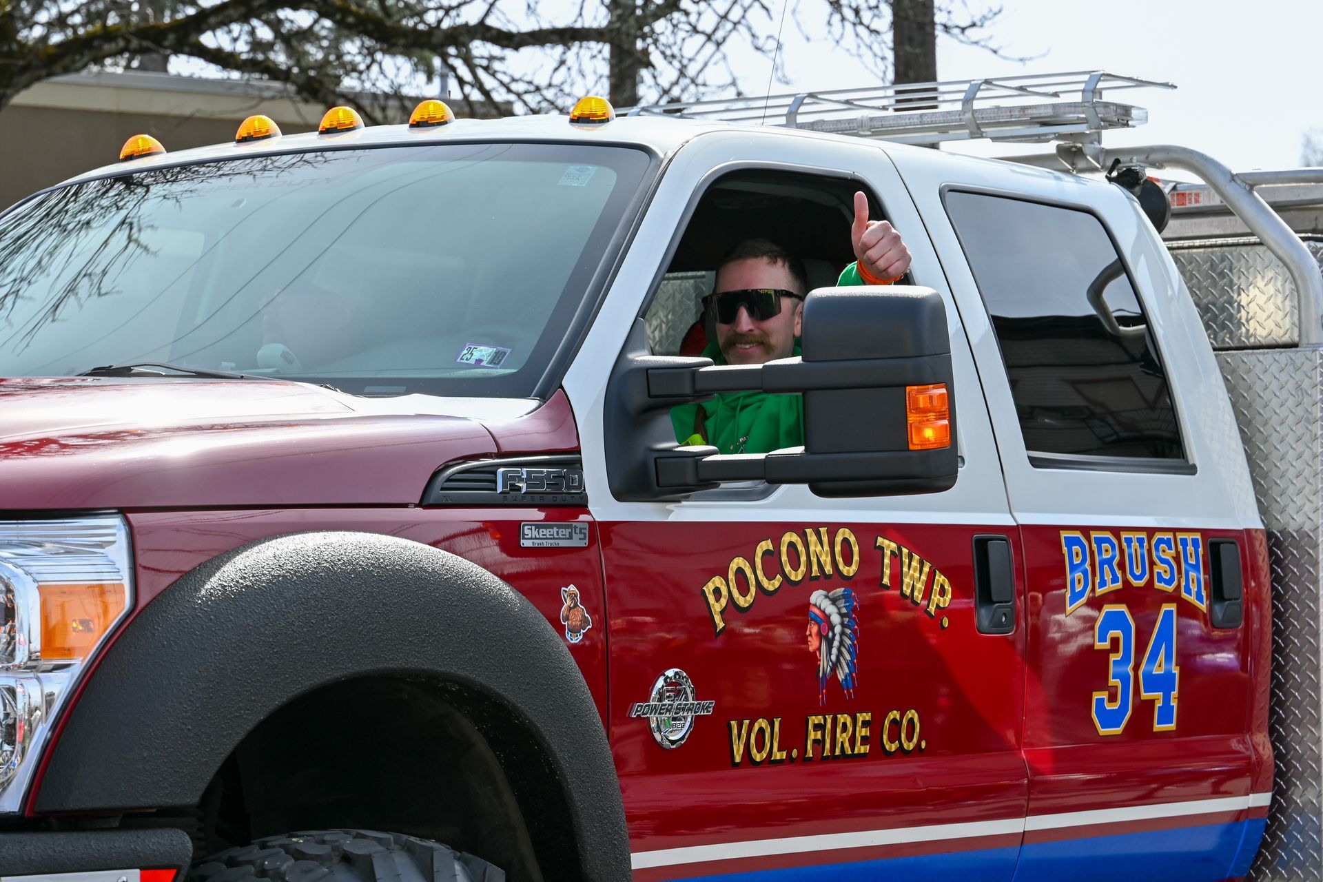A man is driving a red fire truck with the number 34 on it