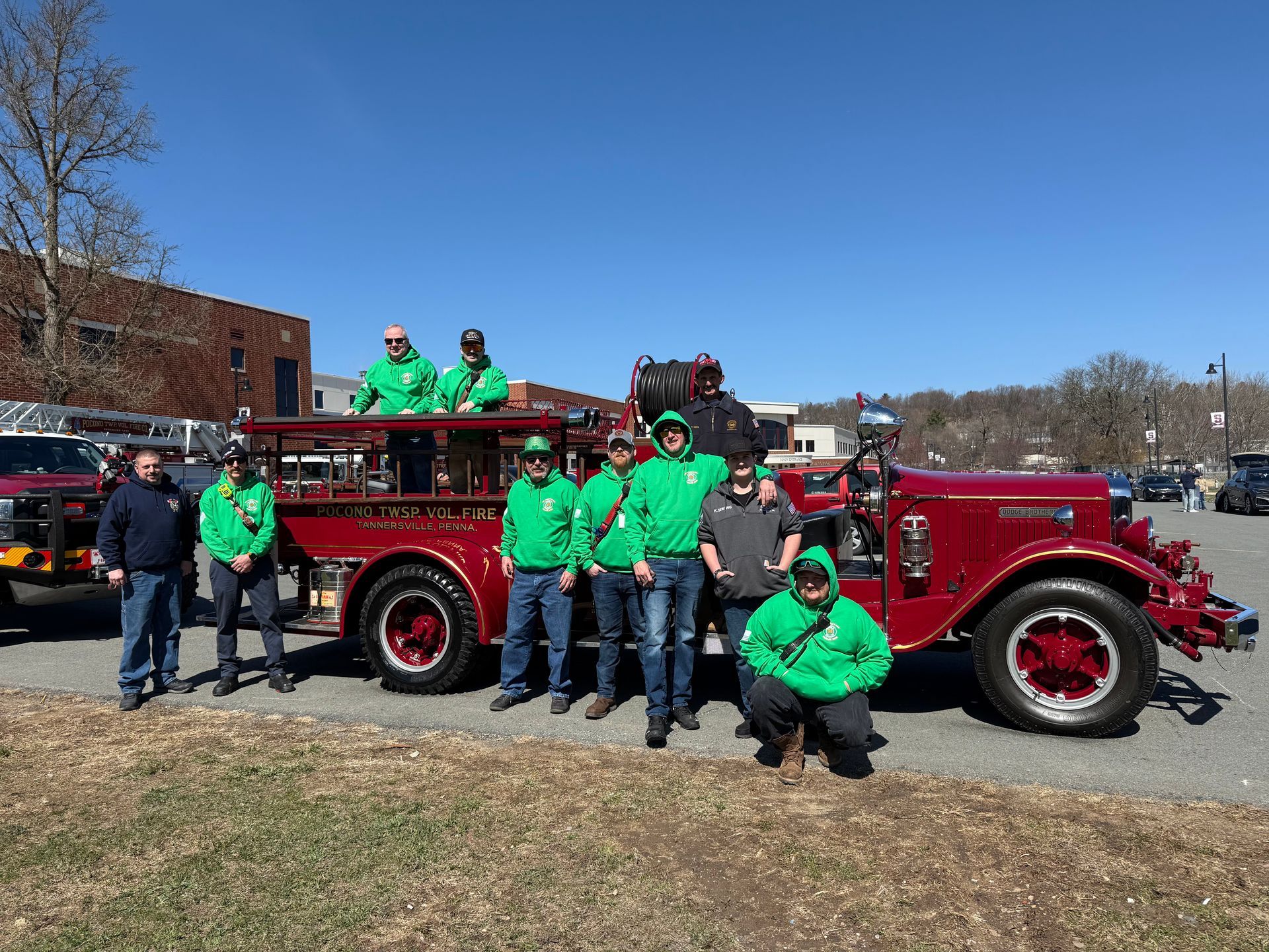 A group of firefighters are posing for a picture in front of 