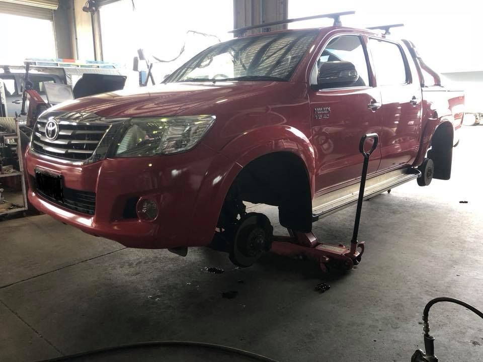 A Red Truck Is On A Jack In A Garage — Torque Tyres & Trailer Spares Mackay in Mackay, QLD