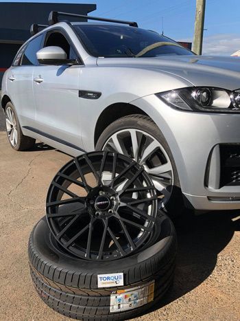 A Silver Car Is Parked Next To A Stack Of Tires And Wheels — Torque Tyres & Trailer Spares Mackay in Mackay, QLD