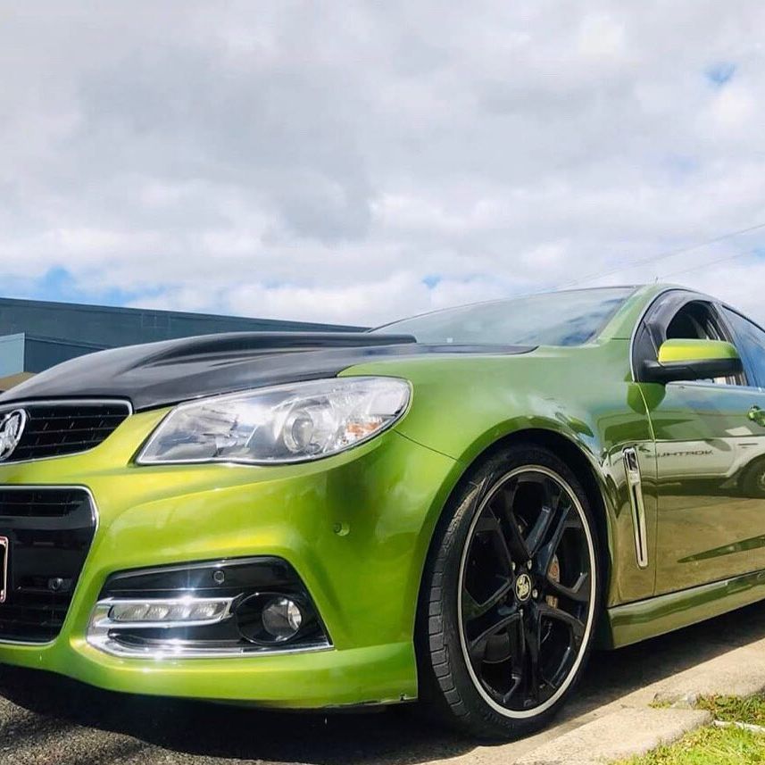 A Green Car With A Black Hood Is Parked On The Side Of The Road — Torque Tyres & Trailer Spares Mackay in Mackay, QLD