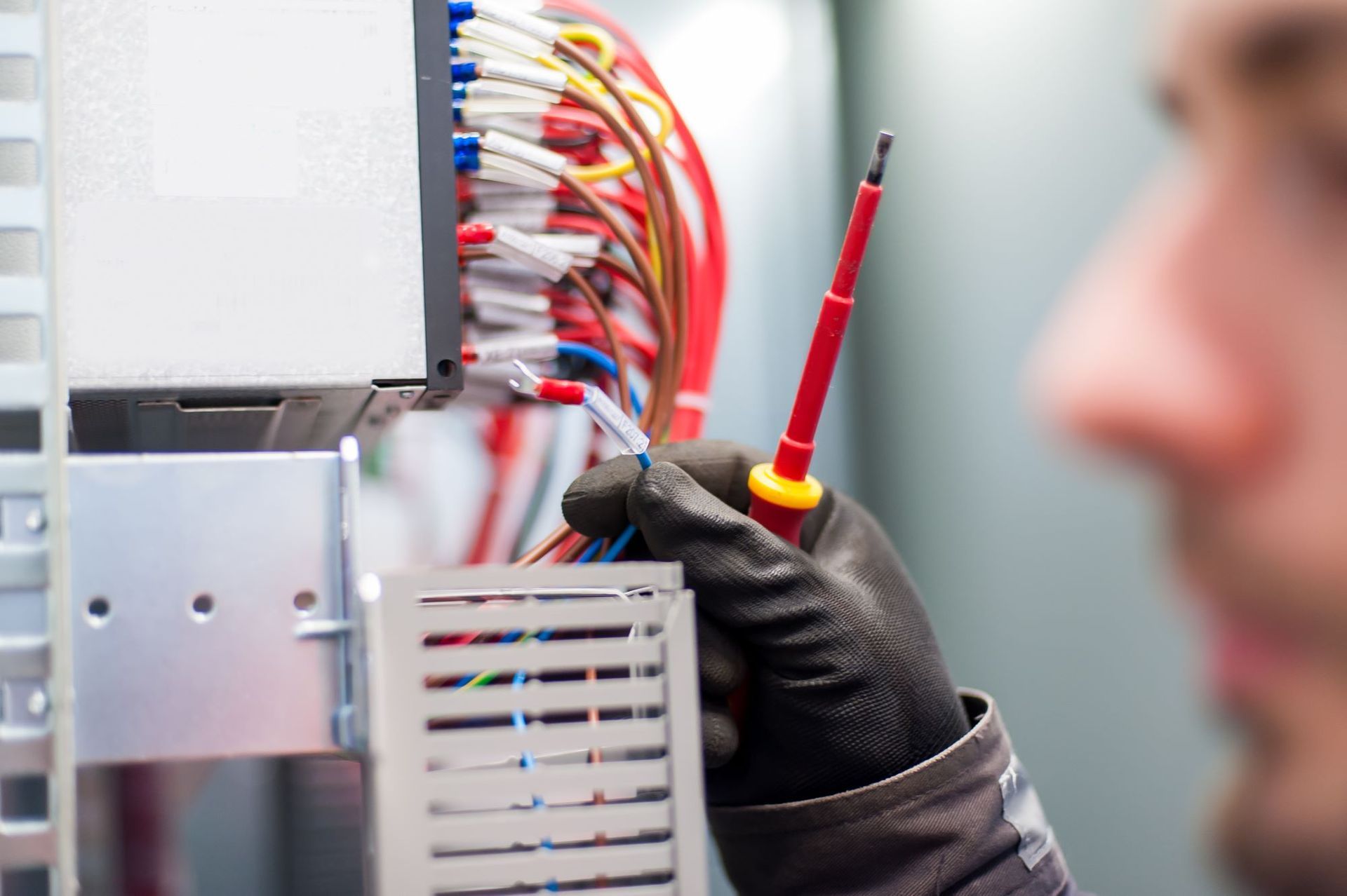 A Man is Holding a Screwdriver in Front of a Bunch of Wires — PH Power in Port Macquarie, NSW